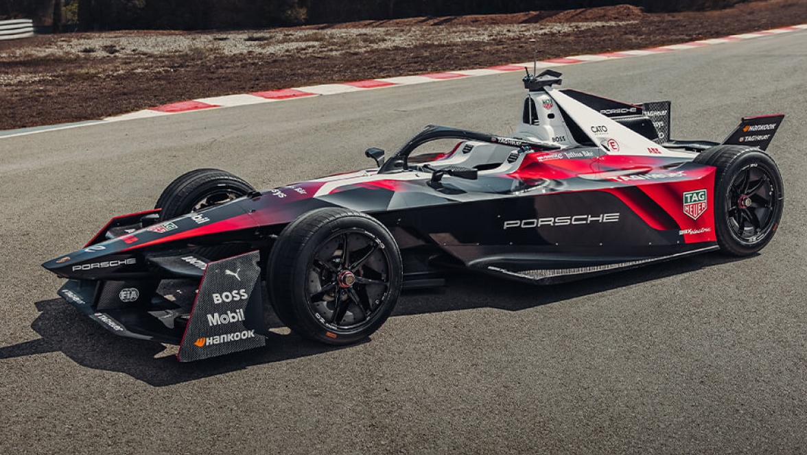 Vista lateral del coche de TAG Heuer Porche Formula E, al aire libre, parado en una pista.