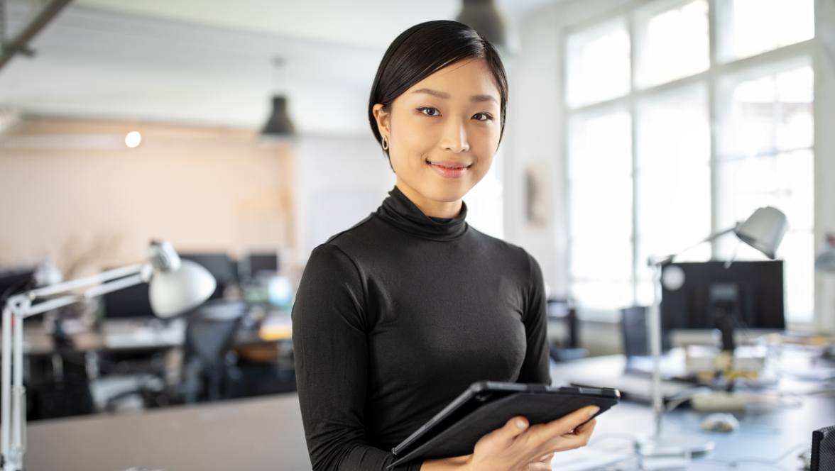 Une personne tient un iPad et pose pour l’appareil