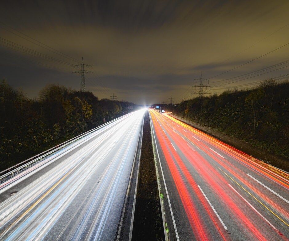 time-lapse image of highway showing streaks of light