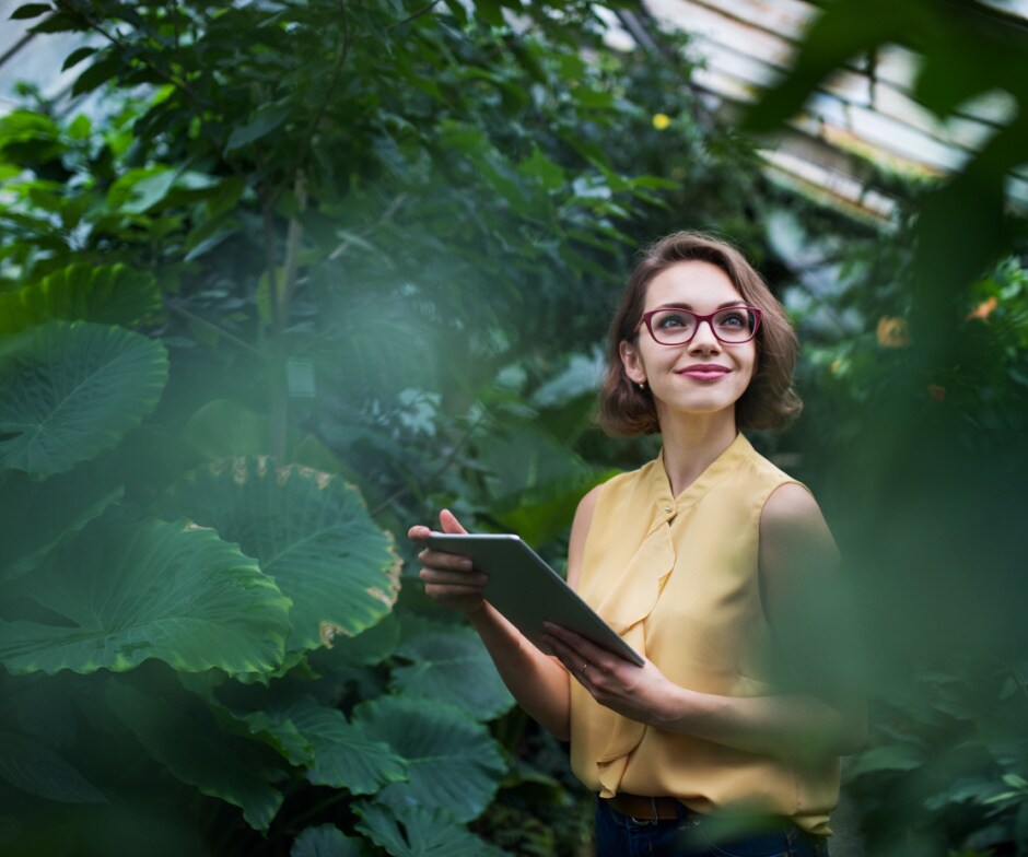 person with tablet in middle of garden