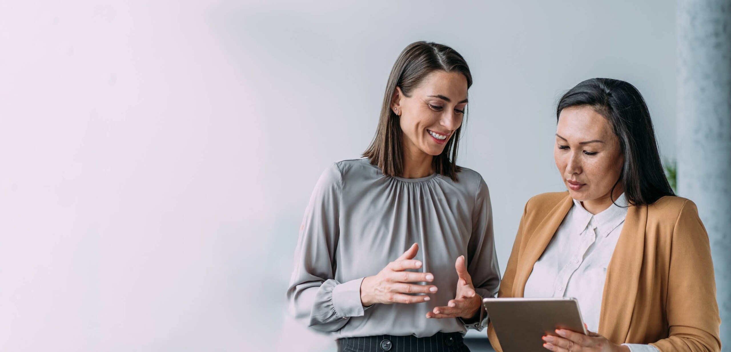 Two persons discussing by looking into the ipad