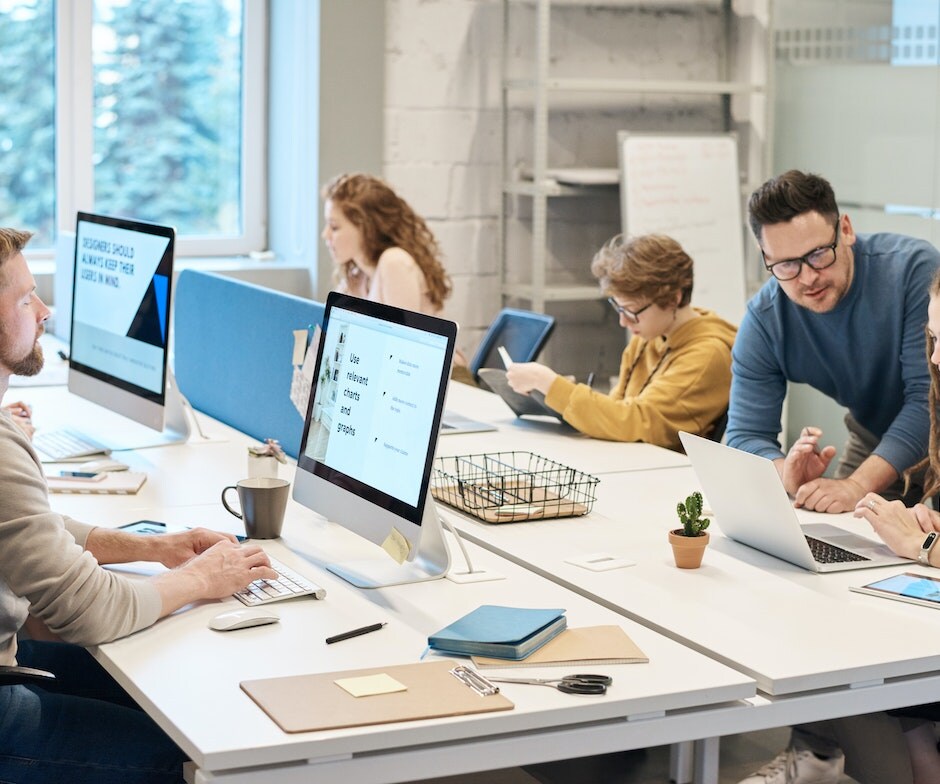 Group of people sitting in a conference room in front of laptops and working