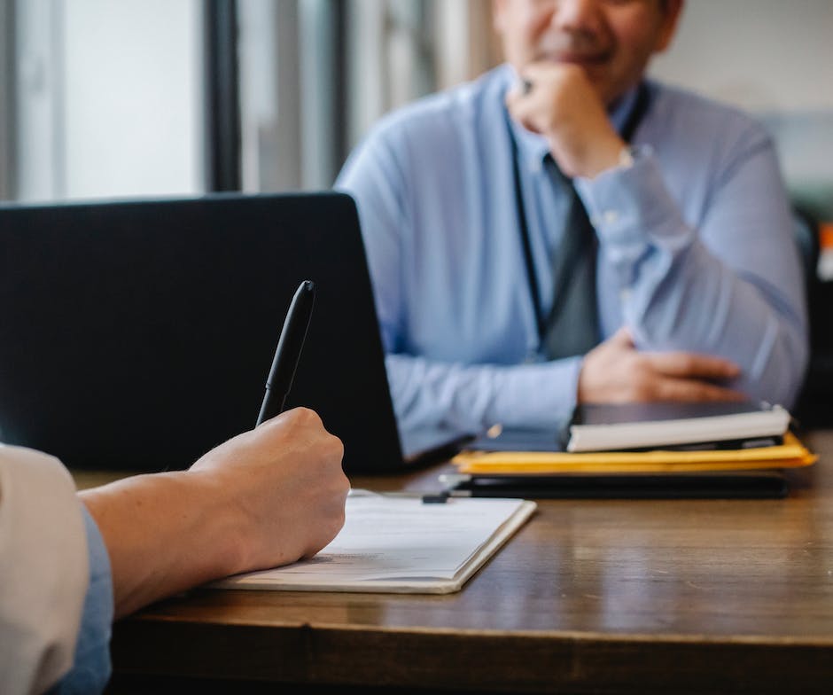 two people sitting in a office room and filling form