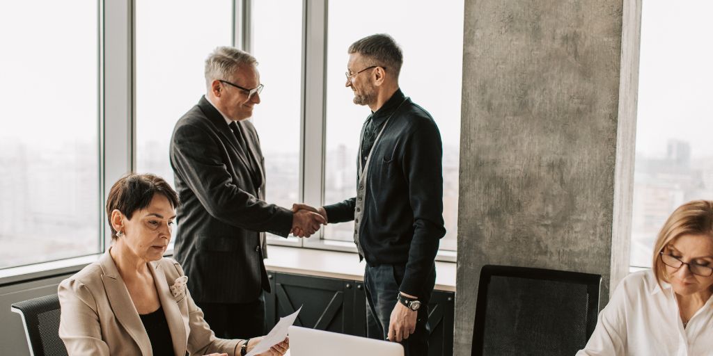 Two men shaking hands in a meeting