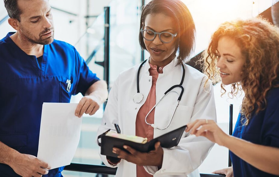 three medical professionals discussing work