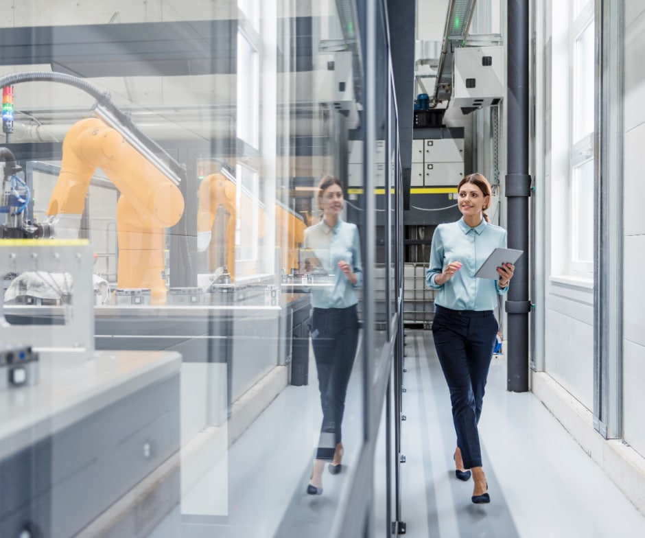 person holding tablet and looking through glass wall while walking