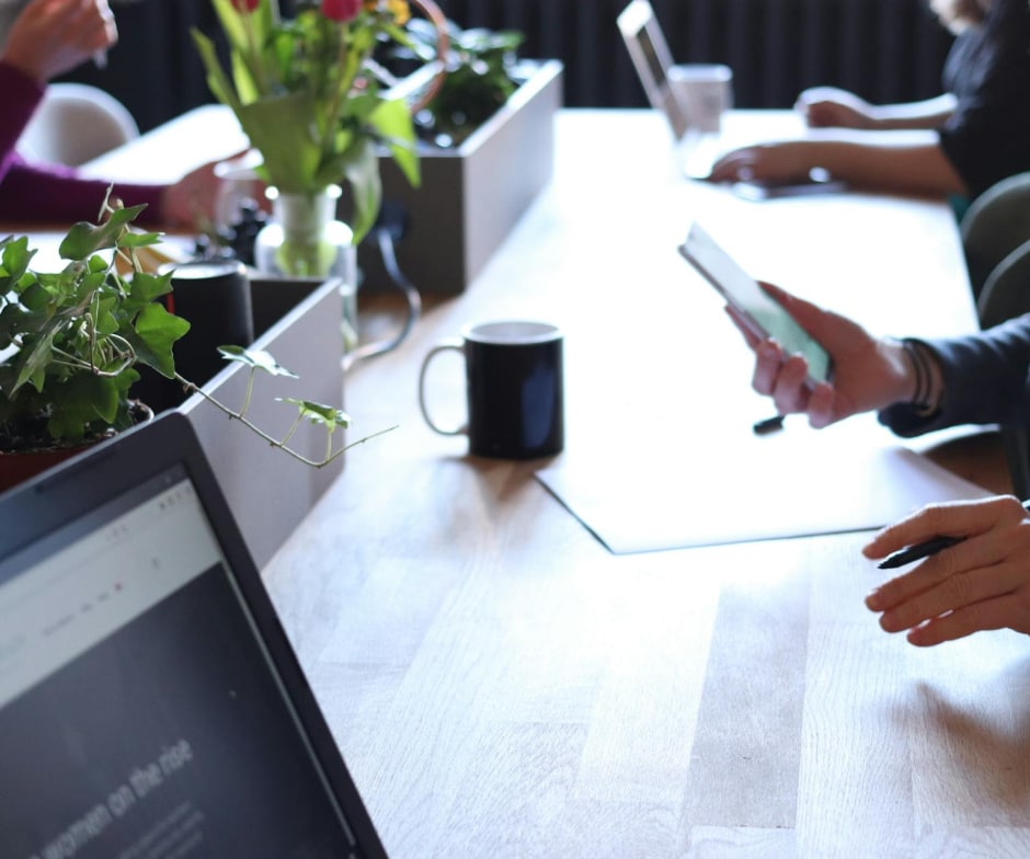 employees sitting inside office table with coffee on the table